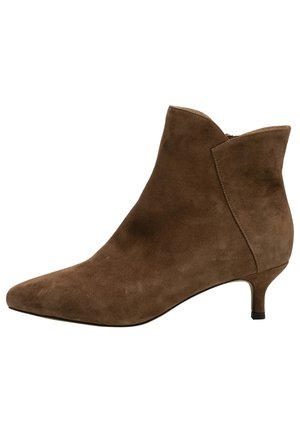 Stivali ankle in suede marrone con punta appuntita, tacco basso e design con tagli angolari. Tessuto liscio, stile minimalista, adatti a vari outfit.