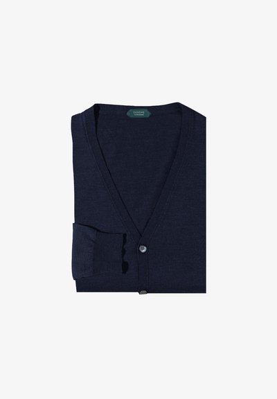 Granatowy kardigan z lekkiego materiału, w dekolcie w serek, z pojedynczym zapięciem na guzik i ściągaczami na mankietach, wyeksponowany w formie złożonej.