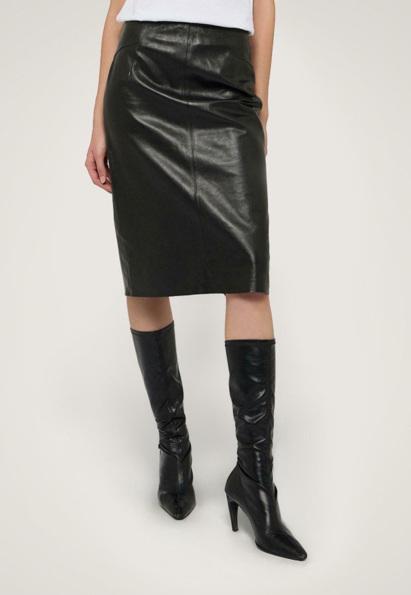 Schwarzer Leder-Bleistiftrock mit glatter Textur, hohem Bund und knielanger Schnitt, kombiniert mit enganliegenden schwarzen Stiefeln bis zum Knie.