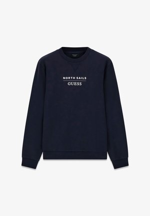 Sweat-shirt bleu marine à col rond avec manches longues, avec texte blanc « NORTH SAILS » et « GUESS » imprimé sur la poitrine.