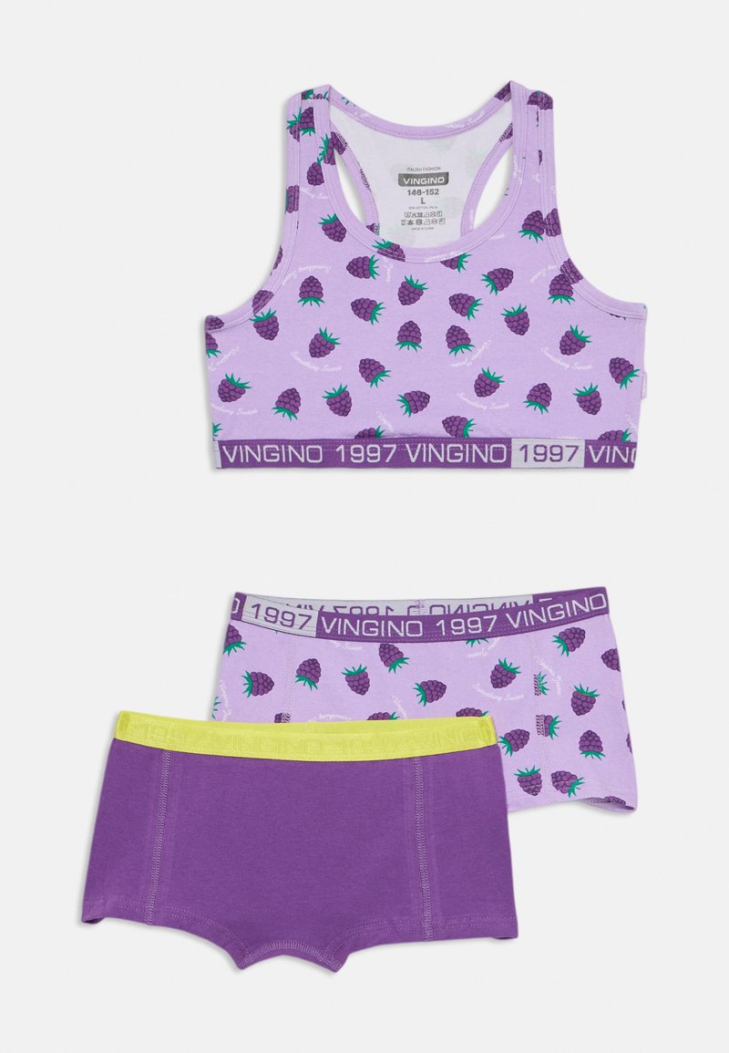 Lila sporta krūšturis ar zaļu ananāsu rakstu, ar purpura joslu, uz kuras ir uzraksts "VINGINO 1997." Zem tā - purpura zemsvārki ar dzeltenu jostu.