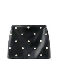 Falda corta de cuero negro con tachuelas plateadas dispuestas en un patrón. Cuenta con un cierre de cremallera lateral y una textura suave.