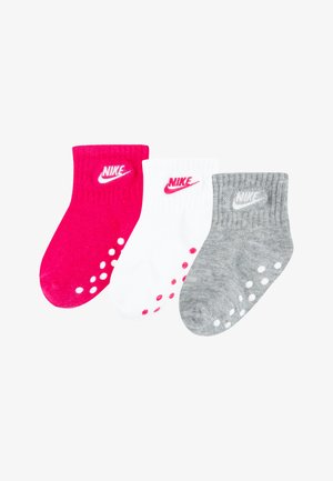 Tre paia di calze Nike: rosa, bianche e grigie. Lunghezza corta a crew, texture a coste, ciascuna con logo e grip a pois sulle suole.