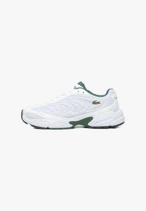 White athletic shoe with a textured upper, green accents, lace closure, and a cushioned sole. Features a small branded logo.