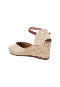 Alpargatas de cuña en beige con tira de tobillo marrón, parte superior de tela suave, detalles de yute trenzado y diseño de talón abierto. Acento a cuadros en la parte trasera.