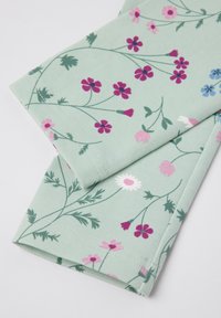 Kukkakuvioinen kangas vaaleanvihreällä taustalla, jossa on vaaleanpunaisia, sinisiä ja valkoisia kukkakuoseja. Kangas on sileäpintainen ja reunat on ommeltu siististi.