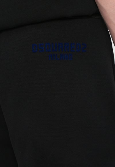 Pantalons de survêtement noirs avec logo brodé bleu "DSQUARED2 MILANO" sur le côté, fabriqués en tissu doux avec une texture lisse.
