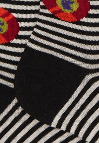 Calze a righe bianche e nere con motivi floreali colorati e dettagli in rosso, arancione, viola e verde, in morbido tessuto lavorato a maglia.