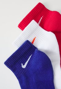 Trekk par med Nike sokker: rød, hvit, og blå. Hver har en ribbet tekstur og har Nike-logoen i kontrasterende farger.