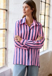 Long-sleeve button-up shirt featuring pink and navy vertical stripes, lightweight fabric, a collar, and a single chest pocket.