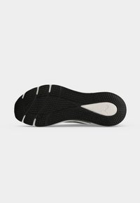 Μαύρη και άσπρη σόλα sneaker με υφή και λογότυπο Puma σε λευκό φόντο.
