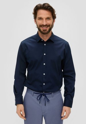 Navyblauwe overhemd met lange mouwen en een button-down kraag, gemaakt van katoen, met witte knopen en een gladde textuur, gecombineerd met grijs gemêleerde broek.