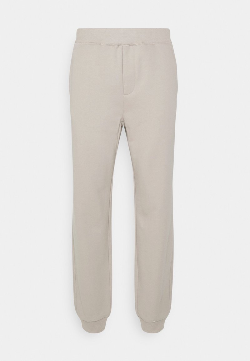 Beige elastic-waist jogger pants with cuffed ankles, front seam detailing, and a smooth, soft fabric texture.