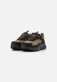 Zwarte en olijfgroene sneakers hebben een textuur bovenkant, verstevigde neus en een robuuste zool met grippatronen. De veters zijn zwart met zilveren accenten.
