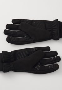 Schwarze Handschuhe aus einem glatten synthetischen Material mit rutschfesten Akzenten an den Fingern und einem weichen, strukturierten Innenfutter. Mit elastischen Bündchen.