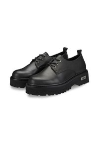 Scarpe in pelle nera con punta arrotondata, design con lacci, suola spessa e texturizzata, e linguetta sul retro; occhielli metallici e dettaglio del marchio sul lato.