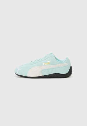 Himmelblå Puma sneakers med hvid stribe og sort sål, set fra siden på en enkel hvid baggrund.