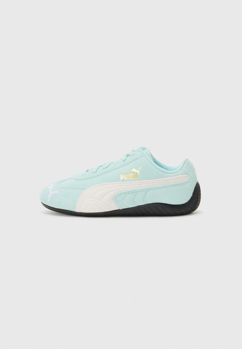 Baskets Puma bleu clair avec une bande blanche et une semelle noire, vue de côté sur fond blanc uni.