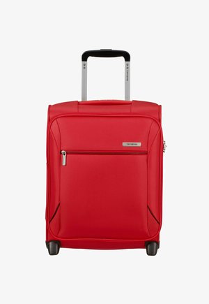 Valise souple rouge avec poignée télescopique, poche zippée à l'avant et roues à la base pour le voyage.