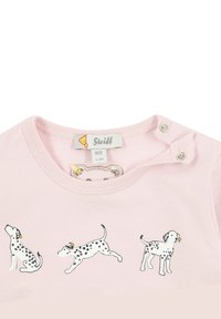 Light pink cotton t-shirt featuring three Dalmatian dog illustrations with black spots and yellow accents. Snap-button closure on shoulder.