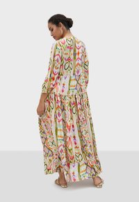 Maxiklänning i lätt tyg med ett färgglatt, abstrakt mönster, volangdesign, långa ärmar och en nyckelhålsöppning bak.