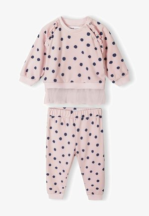 Hele roosa täppidega top, millel on volangi aktsendid ja tüllikihaga, kombineeritud sobivate pükstega. Mõlemad on valmistatud pehmest ja elastsetest materjalidest.