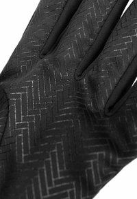 Schwarze Handschuhe mit einem strukturierten Fischgrätenmuster, glatten, anliegenden Fingern und einem weichen, flexiblen Stoff. Keine sichtbaren Hardware-Details.