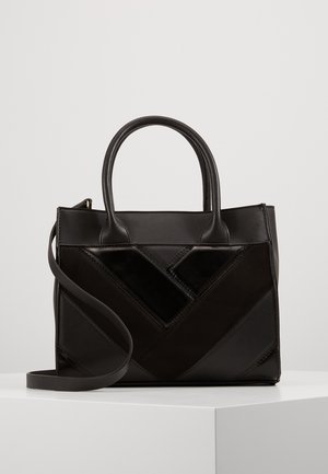 Sort læderhåndtaske med top-håndtag og en lang rem, der har et geometrisk patchwork-mønster på forsiden.