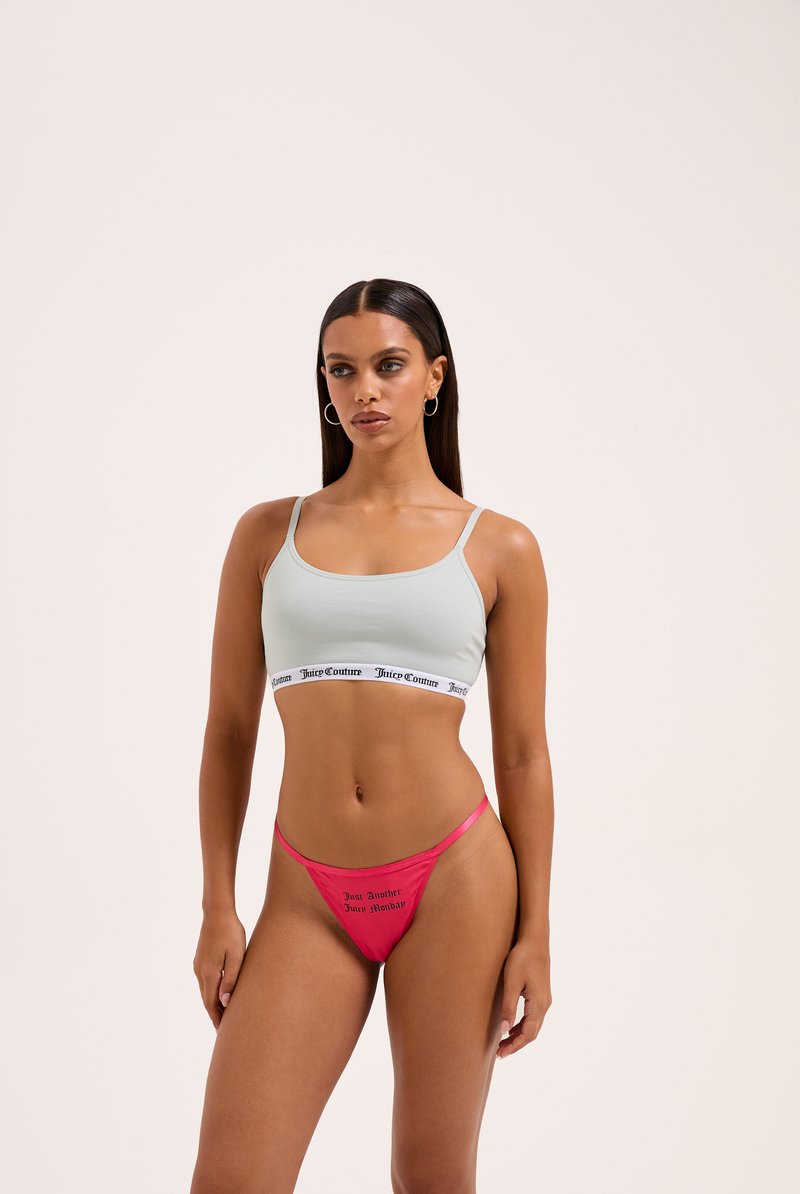 Svetlomodrý crop top s čiernym lemovaním, kombinovaný s jasnoružovými tangami s potlačou textu. Hladká tkanina, uvoľnený strih, minimalistický dizajn.