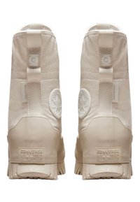 Botas Beige Converse All Star de diseño de caña alta, con parte superior de tejido texturizado, suela de goma y un distintivo logo circular en el talón.