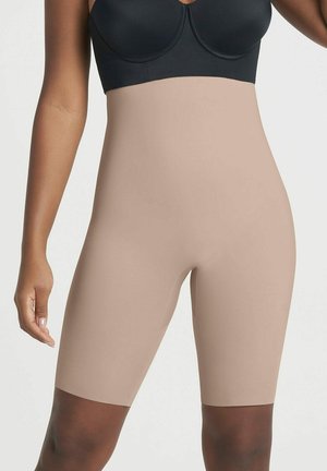 Beige vormgevende shorts van soepel, rekbaar materiaal, met een hoge taille en die tot halverwege het dijbeen reiken, ontworpen voor een naadloze pasvorm.