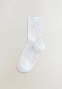 Calzino bianco con testo e motivi rosa chiaro, dotato di una texture a coste e punta rotonda. Tessuto morbido con elastico sulla parte superiore.