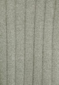 Tejido de suéter de punto en un verde oliva suave. Presenta una textura con relieve vertical y sutiles variaciones en el tono. Material suave y elástico.