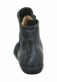 Zwarte leren enklaars met een gestructureerde afwerking, rits aan de achterkant en een gebogen kraag. Soepele zool met een lichte hak.