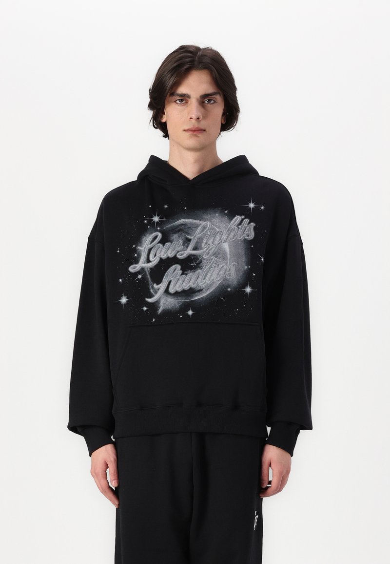 Felpa nera con cappuccio caratterizzata da un design grafico con il testo "Low Lights", stelle e un motivo galattico. Realizzata in morbido tessuto testurizzato con tasca a marsupio.