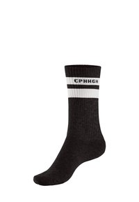 Melnas pieaugušo zeķes ar baltām svītrām tuvu gumijai un ar tekstu "CPWHGH" iestrādātu starp svītrām uz baltas fona.