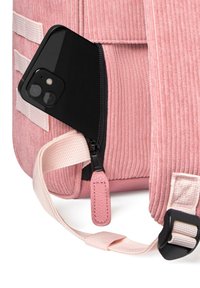 Pink corduroy backpack with a zipper compartment holding a black smartphone, featuring a textured finish and a contrasting strap.
