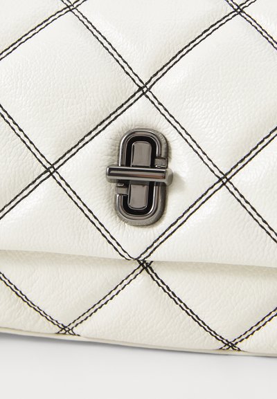Sac en cuir blanc matelassé avec un motif en diamant noir et un fermoir en métal noir brillant. Surface texturée avec des coutures contrastantes.