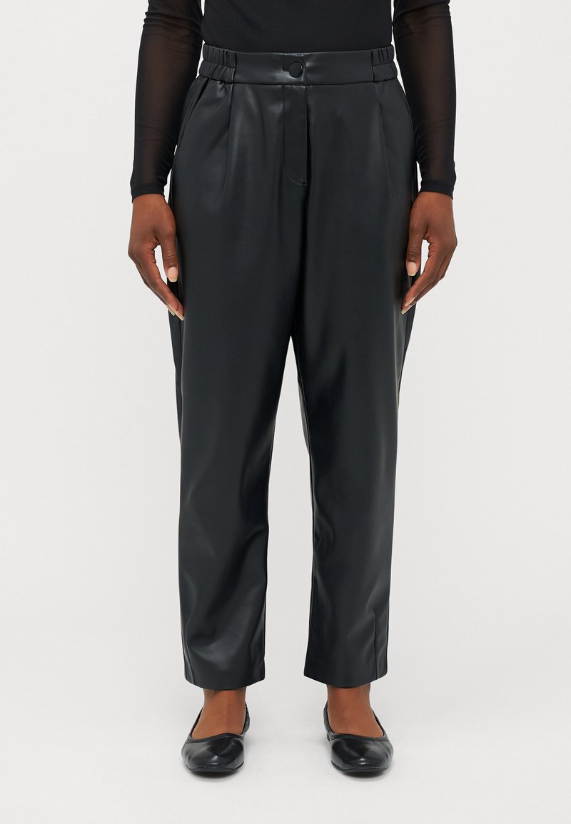 Pantalons en simili cuir noir avec une coupe décontractée, des plis avant, une taille élastique et une fermeture à un bouton. Assortis avec des chaussures plates noires.