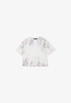 T-shirt court en tissu doux, avec une base blanche claire ornée d'un motif abstrait brun et des manches courtes. Encolure arrondie.