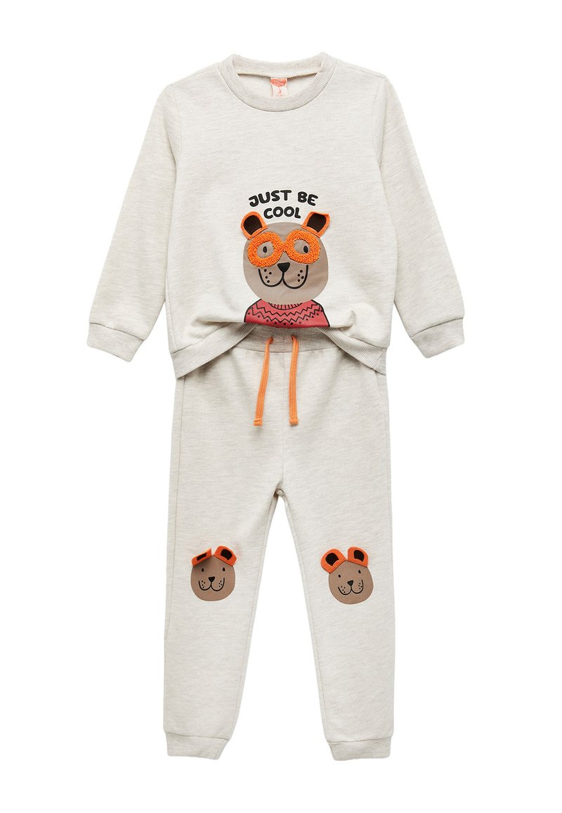 Lys grå sweatshirt og bukser sæt med et bjørne grafik, orange detaljer og teksten "JUST BE COOL". Har elastiske manchetter og talje.
