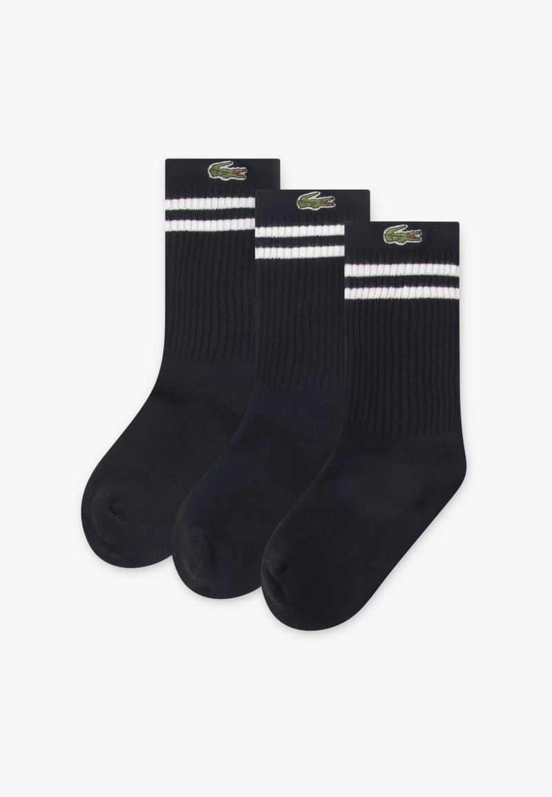 Τρία ζευγάρια σκούρες μπλε κάλτσες με ραβδωτή υφή. Κάθε ζευγάρι έχει δύο λευκές ρίγες στο πάνω μέρος και ένα κεντημένο πράσινο λογότυπο κροκοδείλου.