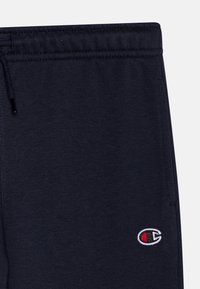 Marineblaue Jogginghose aus weichem Stoff, mit einem elastischen Bund und Kordelzug sowie einem kleinen, gestickten Logo in Weiß und Rot.