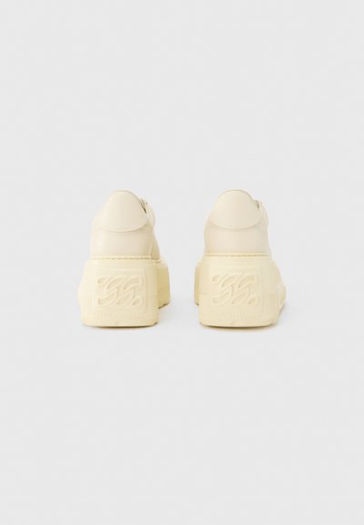 Baskets épaisses en cuir lisse, dotées d'une semelle texturée surélevée et de détails subtils avec le logo à l'arrière.