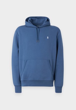 Blauwe hoodie van zacht materiaal met een voorzak, een capuchon met trekkoord en een wit logo-detail op de borst. Heeft ribgebreide manchetten en een zoom.