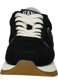 Schwarze Wildleder-Sneaker mit weißen Schnürsenkeln, grauen Akzenten und einer strukturierten Gummisohle. Verfügt über ein gestepptes Design und ein Logo auf der Zunge.