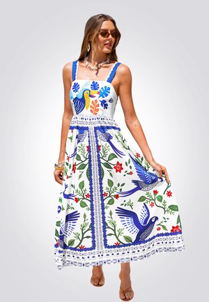 Witte maxi-jurk met blauwe, groene en rode bloemen- en vogelpatronen, voorzien van een aansluitend lijfje, brede bandjes en decoratieve afwerking.