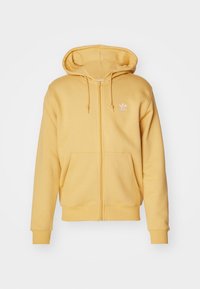 Gul zip-up hoodie i mjukt tyg, med en framficka, dragsko i huvan och en liten vit logotyp på vänster bröst.