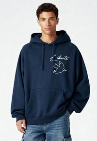 Sweat à capuche bleu marine avec une poche avant, présentant le texte blanc "Liberté" et un motif d'oiseau. Confectionné en tissu doux et texturé avec une coupe décontractée.