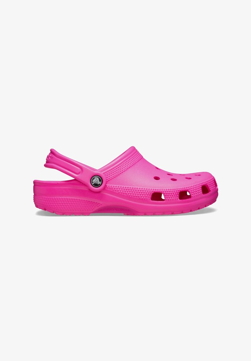 Sabot en caoutchouc rose vif avec des trous de ventilation et une bride de talon mobile, montré de côté sur fond blanc.